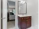Well-lit bathroom featuring a vanity with a wooden cabinet and a doorway leading to a bedroom at 1721 White Pond Ln, Waxhaw, NC 28173