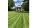 Stately brick home with white columns and meticulously striped lawn creates a grand and inviting curb appeal at 1721 White Pond Ln, Waxhaw, NC 28173