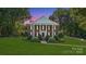 Stately brick home with white columns, black shutters, manicured lawn, and mature trees at 1721 White Pond Ln, Waxhaw, NC 28173
