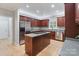 Bright kitchen featuring an island cooktop, stainless steel appliances, and natural wood floors at 1721 White Pond Ln, Waxhaw, NC 28173