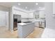 The updated kitchen features stainless appliances, an island cooktop, and white cabinets for ample storage at 1721 White Pond Ln, Waxhaw, NC 28173