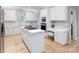 Bright white kitchen features an island with a cooktop, ample cabinets, and an adjacent workstation at 1721 White Pond Ln, Waxhaw, NC 28173