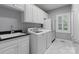 Convenient laundry room with white cabinets, sink, and modern washer and dryer set at 1721 White Pond Ln, Waxhaw, NC 28173