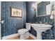 Stylish powder room featuring patterned wallpaper and a pedestal sink for a touch of classic elegance at 1721 White Pond Ln, Waxhaw, NC 28173