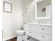 Bright half bath featuring a white vanity, white countertops, soft paint, and hardwood floors at 18027 Train Station Dr, Cornelius, NC 28031