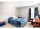 Cozy bedroom with a blue bed, a dark-curtained window, carpet, and a side table with a lamp at 18027 Train Station Dr, Cornelius, NC 28031