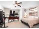 Well-lit bedroom featuring a ceiling fan, carpet, a large desk, and a comfortable bed at 18027 Train Station Dr, Cornelius, NC 28031