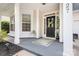 Charming front porch with a black front door, a leafy green welcome mat, and decorative floral arrangements at 18027 Train Station Dr, Cornelius, NC 28031