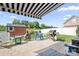 Inviting backyard patio with awning, featuring a grilling area, fire pit, and comfortable seating for outdoor relaxation at 18027 Train Station Dr, Cornelius, NC 28031
