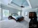 This is a spacious bedroom with a unique tray ceiling and fan, plus an en suite bathroom at 19409 Laurel Glen Ave, Cornelius, NC 28031