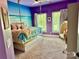 Vibrant purple bedroom with ocean wall decor, swing chair, and plenty of natural light at 19409 Laurel Glen Ave, Cornelius, NC 28031