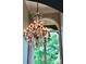 Ornate chandelier hanging in front of a large window with a green view at 19409 Laurel Glen Ave, Cornelius, NC 28031