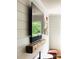 There is a TV mounted above a wooden shelf that adds charm and a modern touch to this living room at 19409 Laurel Glen Ave, Cornelius, NC 28031