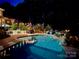 Outdoor pool at night featuring landscape lighting, lush foliage, and comfortable lounge seating at 19409 Laurel Glen Ave, Cornelius, NC 28031