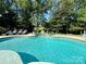 Sparkling in-ground pool with waterfall feature and lounge chairs surrounded by trees at 19409 Laurel Glen Ave, Cornelius, NC 28031