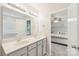 Bright bathroom features a double sink vanity, a large mirror, and a view into the cozy bedroom at 217 Almora Loop, Mooresville, NC 28115