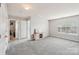 A gray carpeted living room with natural light and a wooden entertainment stand is ready for relaxing and entertaining at 217 Almora Loop, Mooresville, NC 28115