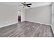 Empty bedroom with wood-look floors and ceiling fan, with a partial view of an attached bathroom at 2751 Bramble Ridge Ct, Charlotte, NC 28215