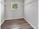 Spacious walk-in closet features durable flooring, rod and shelves and a bright window at 2751 Bramble Ridge Ct, Charlotte, NC 28215