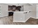 Modern kitchen featuring dark cabinets, stainless steel appliances, breakfast bar, and wood flooring at 2751 Bramble Ridge Ct, Charlotte, NC 28215