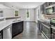 Kitchen with wood floors, stainless steel dishwasher, dark cabinets, and breakfast bar overlooking living area at 2751 Bramble Ridge Ct, Charlotte, NC 28215