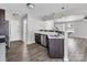 Bright kitchen featuring dark cabinets, a breakfast bar with sink, stainless steel dishwasher, and wood-look floors at 2751 Bramble Ridge Ct, Charlotte, NC 28215