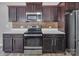 A kitchen with dark brown cabinets, stainless steel appliances, tile backsplash, and white countertops at 2751 Bramble Ridge Ct, Charlotte, NC 28215