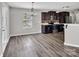Kitchen with dark cabinets, stainless steel appliances, breakfast bar, modern chandelier, and wood flooring at 2751 Bramble Ridge Ct, Charlotte, NC 28215
