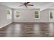 Bright and spacious living room featuring two windows, wood floors, white walls, and a ceiling fan at 2751 Bramble Ridge Ct, Charlotte, NC 28215