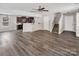 Open-concept living room with hardwood floors, a ceiling fan, a breakfast bar, and staircase to upper level at 2751 Bramble Ridge Ct, Charlotte, NC 28215