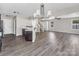 Open-concept living room with wood-look floors, modern chandelier, and staircase visible at 2751 Bramble Ridge Ct, Charlotte, NC 28215