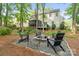 Secluded backyard with a fire pit, comfortable seating, and surrounding mature trees at 3134 Old Chapel Ln, Charlotte, NC 28210