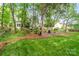 Serene backyard with mature trees, a fire pit area, and landscaping, creating a private outdoor retreat at 3134 Old Chapel Ln, Charlotte, NC 28210