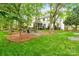 Spacious backyard featuring lush green grass, mature trees, and a cozy fire pit area, perfect for outdoor entertaining at 3134 Old Chapel Ln, Charlotte, NC 28210