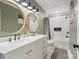 Elegant bathroom features a double sink vanity, round mirrors and a subway tile shower at 3134 Old Chapel Ln, Charlotte, NC 28210