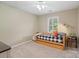 Cozy bedroom features a twin bed with a patterned cover and a bright window at 3134 Old Chapel Ln, Charlotte, NC 28210