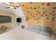 Spacious bonus room with a climbing wall, a gray sofa, and a TV for entertainment at 3134 Old Chapel Ln, Charlotte, NC 28210