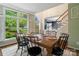 Bright dining room with large windows, a wooden table, and a view of the lush greenery outside at 3134 Old Chapel Ln, Charlotte, NC 28210