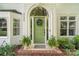 Charming front entrance featuring a green door with a wreath and potted plants on brick steps at 3134 Old Chapel Ln, Charlotte, NC 28210