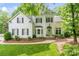 Charming two-story home with a well-manicured lawn, lush landscaping, and a welcoming green front door at 3134 Old Chapel Ln, Charlotte, NC 28210
