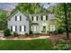 Charming two-story home with a well-manicured lawn, lush landscaping, and a welcoming green front door at 3134 Old Chapel Ln, Charlotte, NC 28210