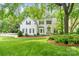 Charming two-story home with a well-manicured lawn, lush landscaping, and a welcoming green front door at 3134 Old Chapel Ln, Charlotte, NC 28210