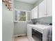 Efficient laundry room equipped with modern washer and dryer units, complemented by ample storage cabinets and a window at 3134 Old Chapel Ln, Charlotte, NC 28210