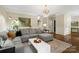 Open-concept living room featuring a gray sectional sofa, hardwood floors, and contemporary lighting at 3134 Old Chapel Ln, Charlotte, NC 28210