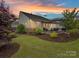 Lush backyard featuring a stone-accented patio area, privacy fence, mature trees, and well-manicured landscaping at 3333 Oliver Stanley Trl, Lancaster, SC 29720