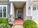 Inviting entryway with decorative wreath, lush landscaping, and covered porch at 3333 Oliver Stanley Trl, Lancaster, SC 29720