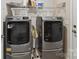 Modern laundry room with front-load washer and dryer, storage shelves, and neutral finishes at 3333 Oliver Stanley Trl, Lancaster, SC 29720