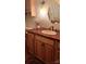 Elegant bathroom vanity featuring a unique sink, granite countertop, and wood cabinets, complemented by accessories at 425 Roselawn Pl, Charlotte, NC 28211