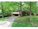Charming home with a long driveway and lush green lawn, nestled among mature trees at 425 Roselawn Pl, Charlotte, NC 28211