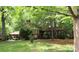Ranch-style home with mature trees, lush lawn, and carport at 425 Roselawn Pl, Charlotte, NC 28211